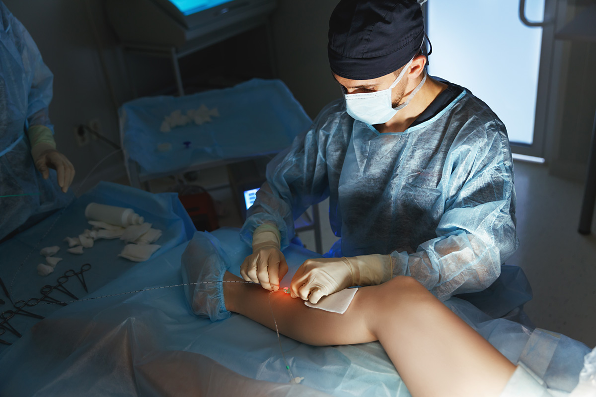 A vascular surgeon performing a procedure on a patient’s leg in El Paso.