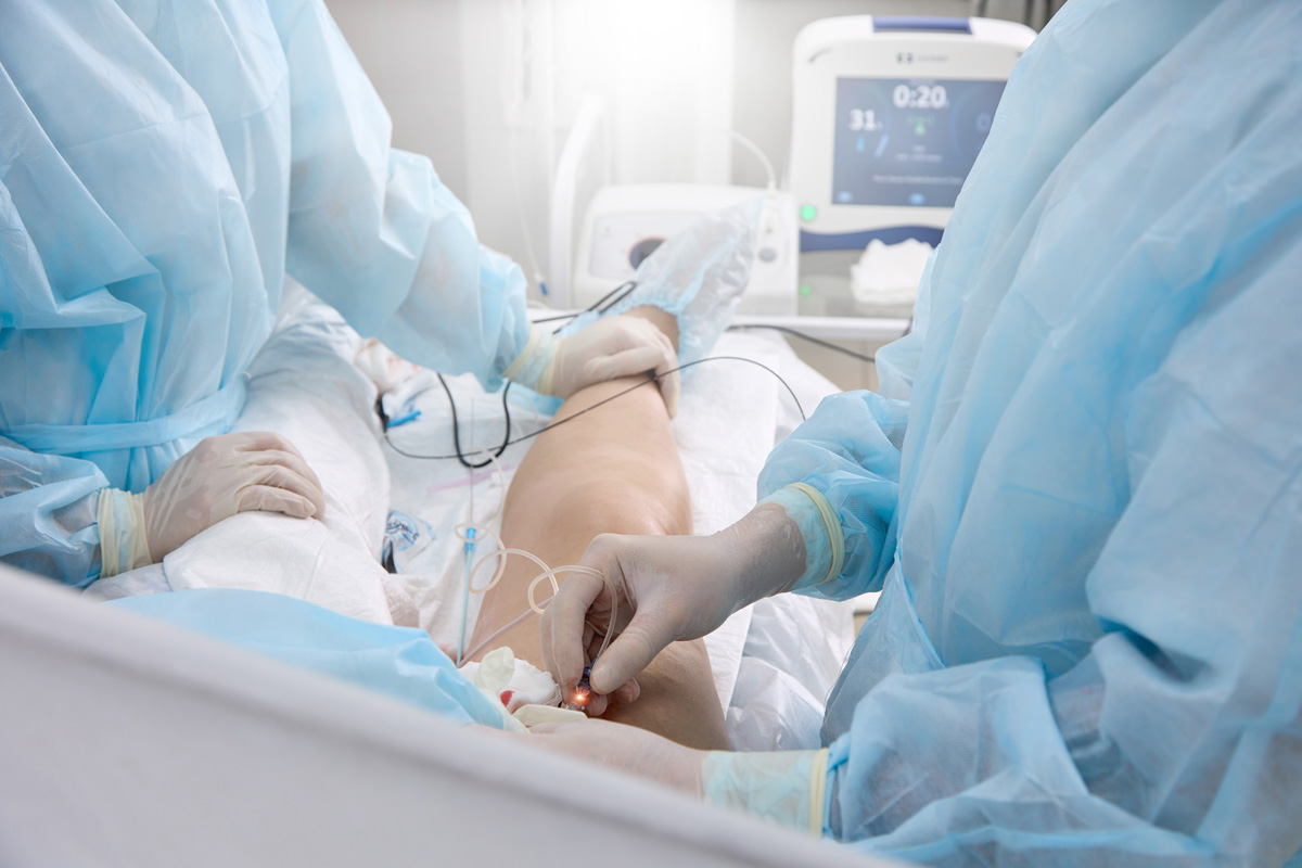 Two vascular surgeons performing surgery on a patient's leg in El Paso.