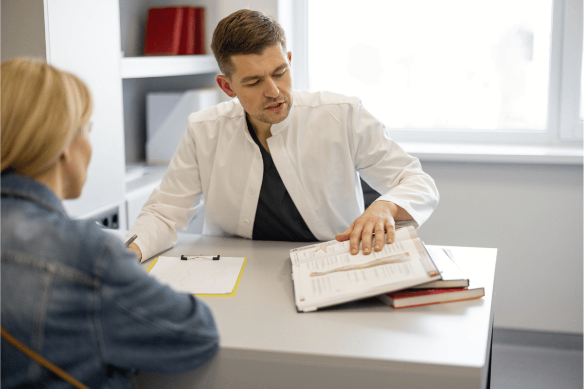 A woman and vascular surgeon sitting at a desk going over paperwork.